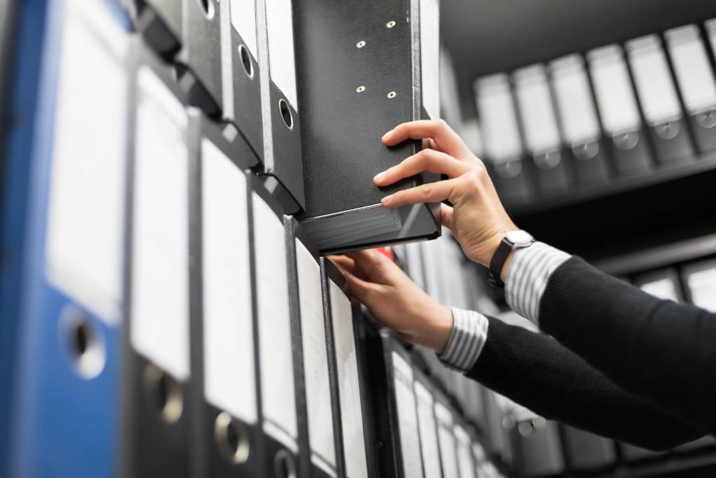 Woman removing file folder from shelf