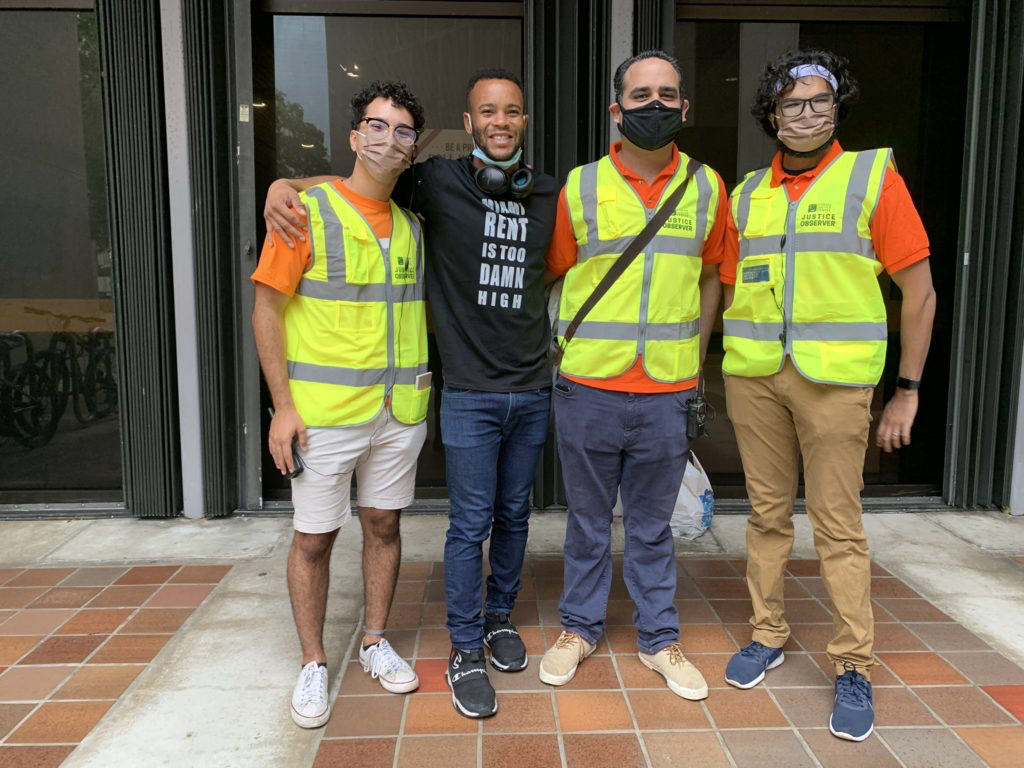 four people stand together wearing bright safety vests