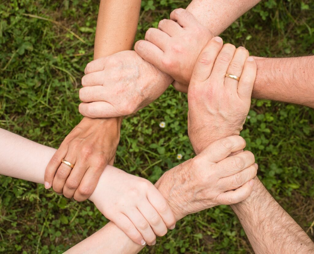 Diverse hands reaching out to help eachother