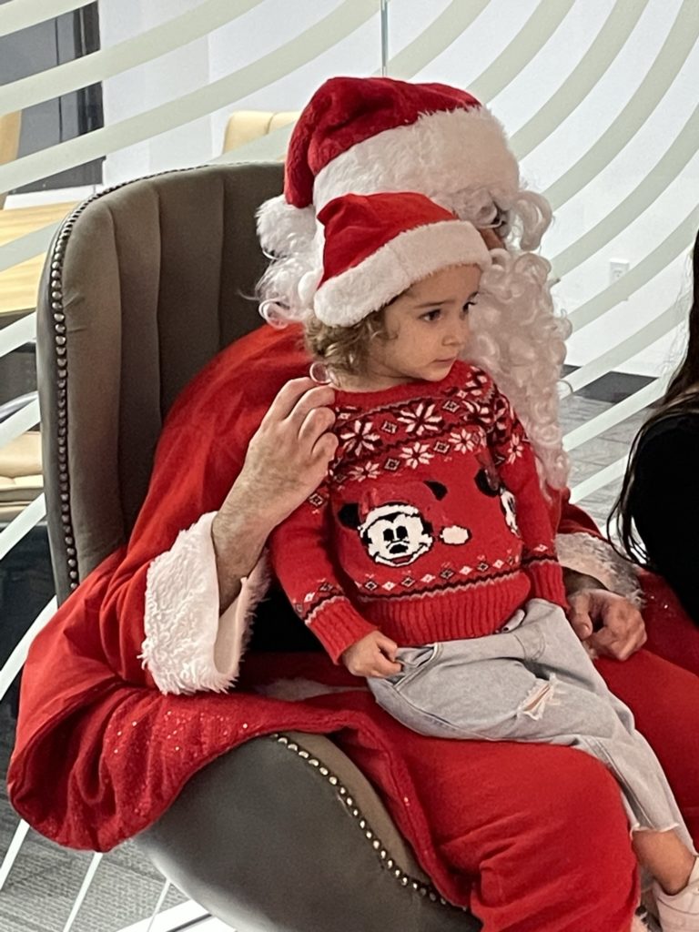 Florida Justice Center Director of Legal Services Alex Saiz dressed as Santa Claus with a child on his lap